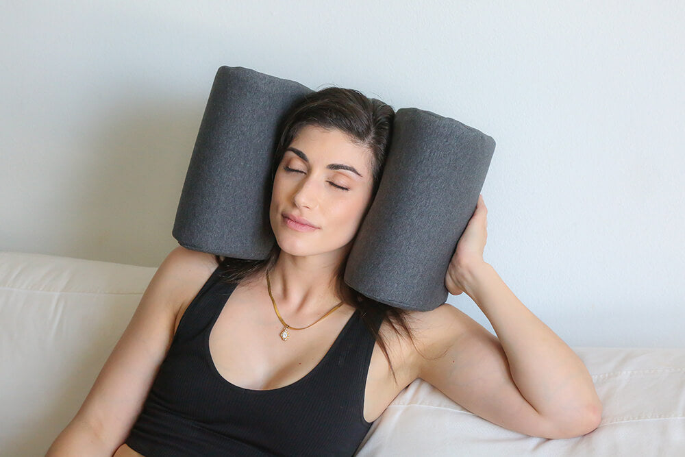 a woman is sleeping with a noise cancelling pillow with headphones that blocks sounds.